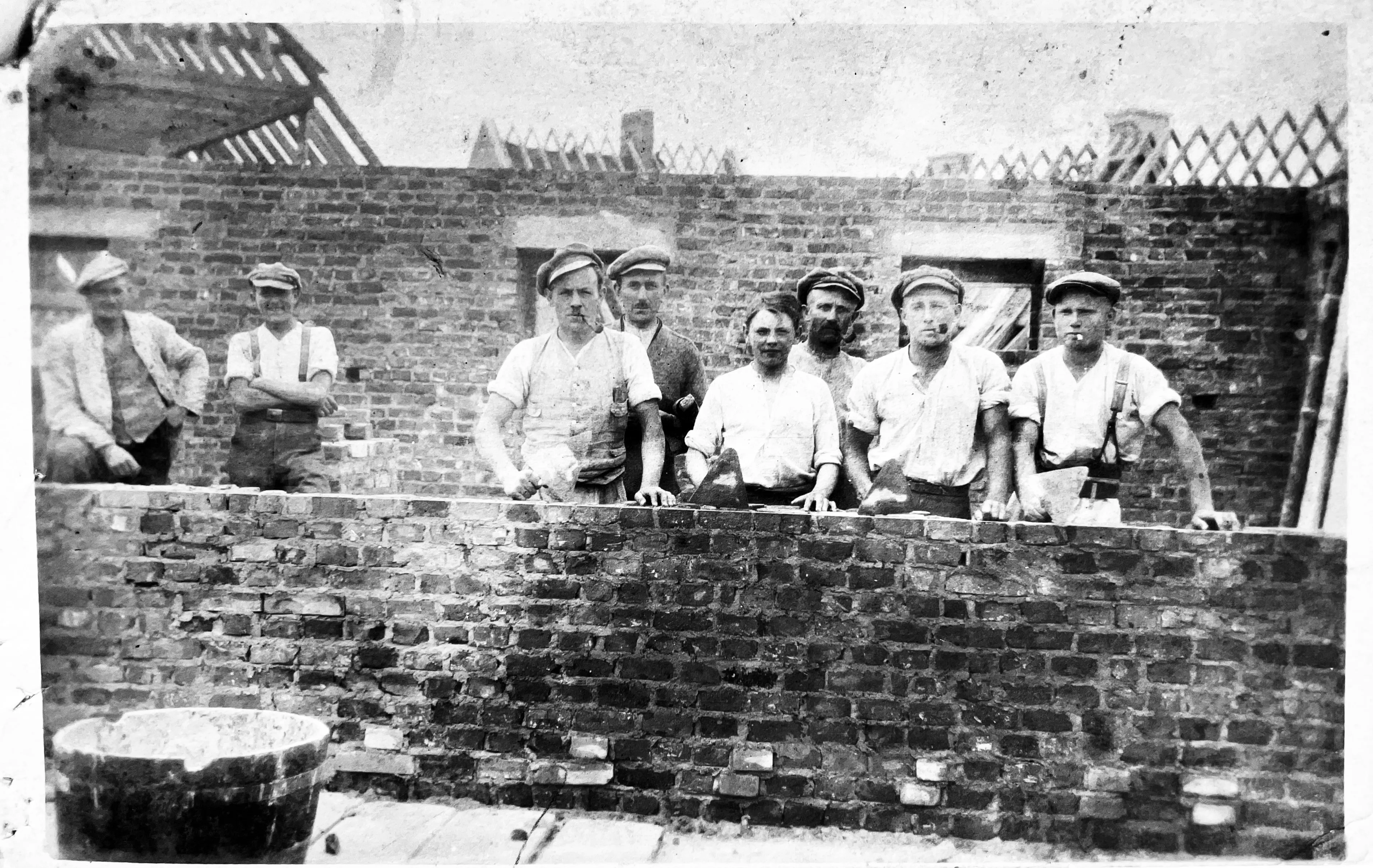 Bauarbeiter aus den 1920er Jahren vor einem Haus im Rohbau