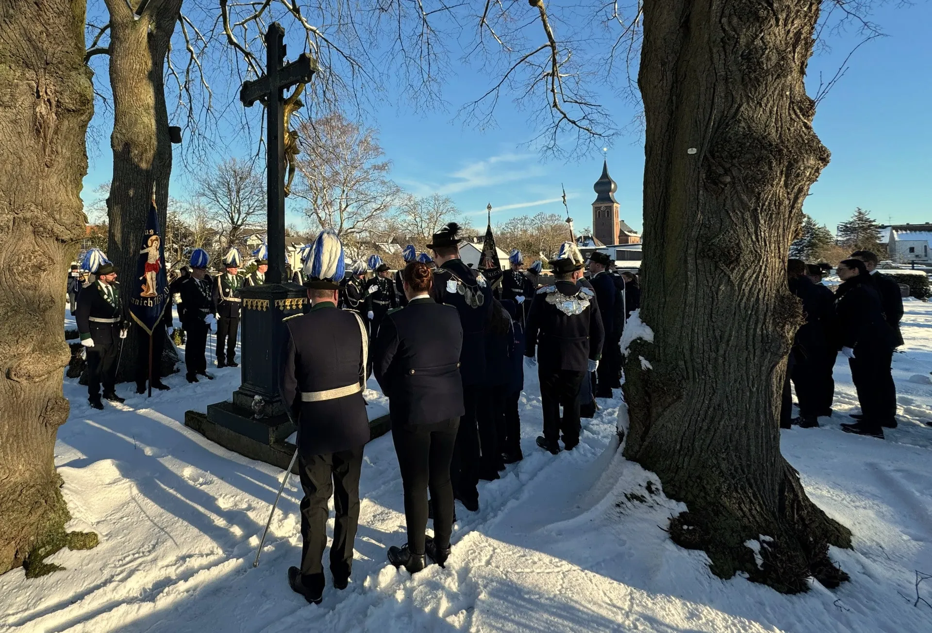 Die Mitglieder auf dem schneebedeckten Friedhof