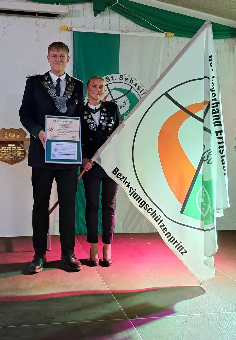 Bezirksprinz Jonas Flohr mit Siegerurkunde und Hanna Schorn mit der Fahne des Bezirksjungschützenprinzen