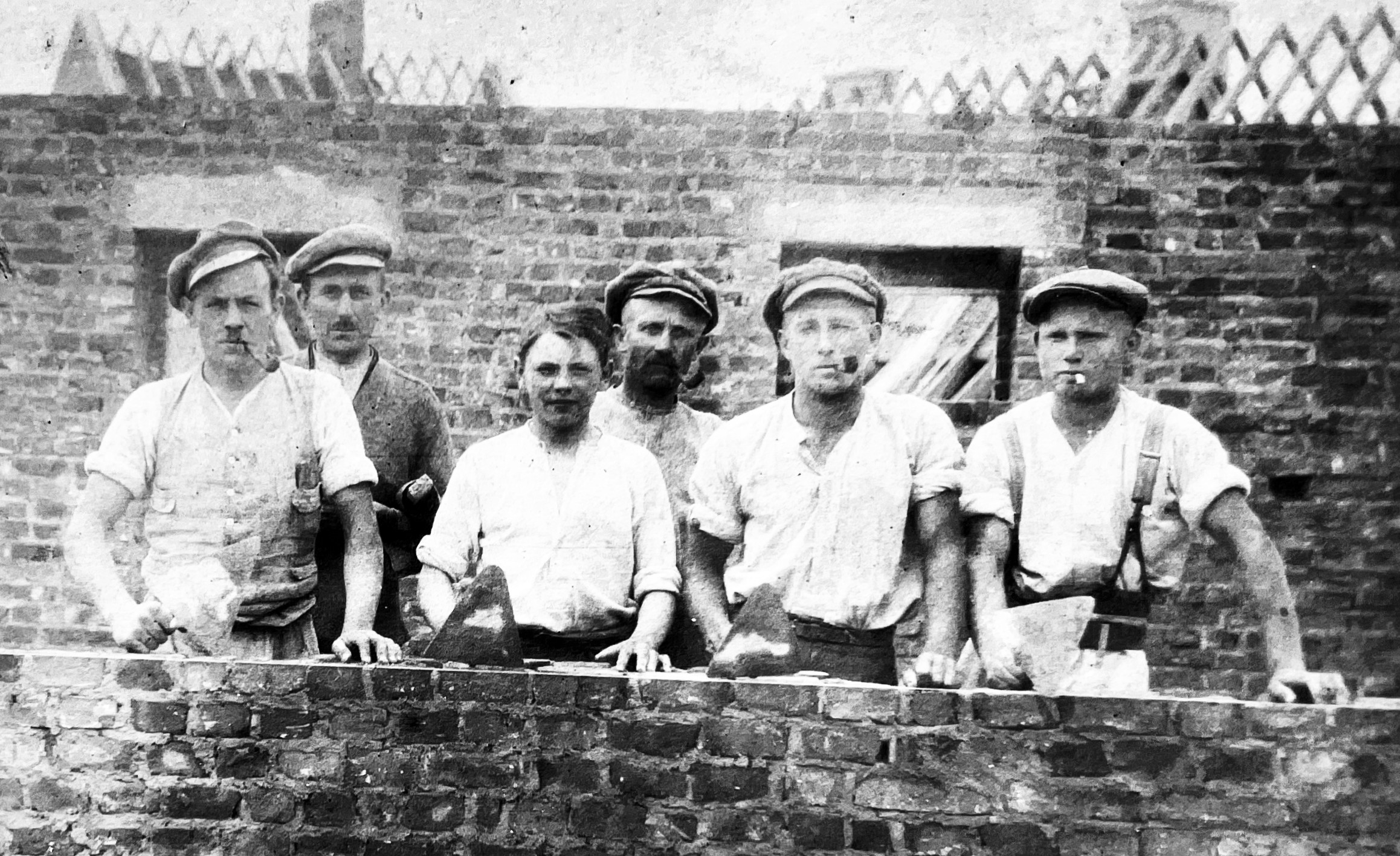 Bauarbeiter aus den 1920er Jahren vor einem Haus im Rohbau, vergrößert rechts