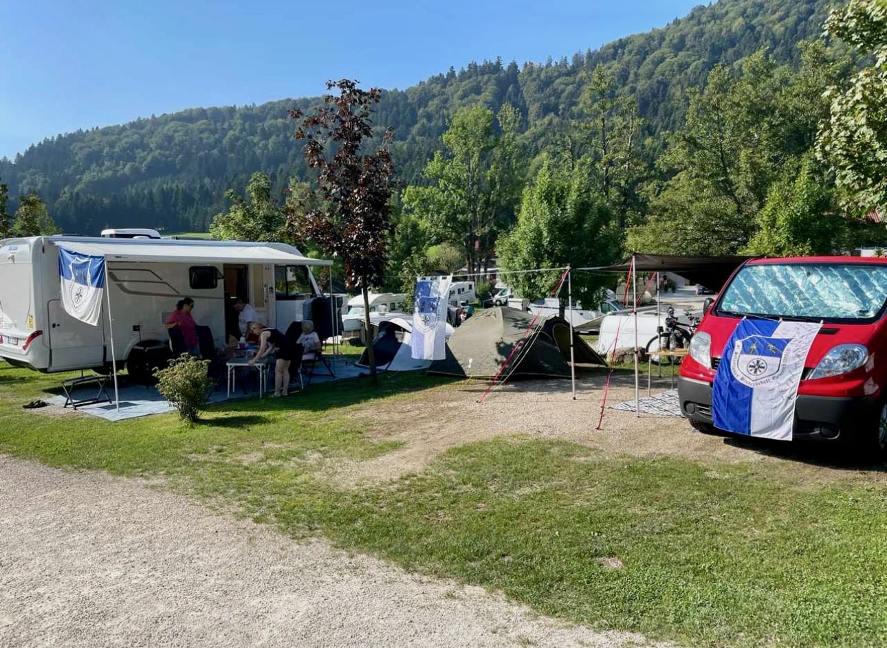 Das aufgeschlagene Lager der Mitgereisten auf einem Campingplatz mit Fahnen der Bruderschaft dekoriert